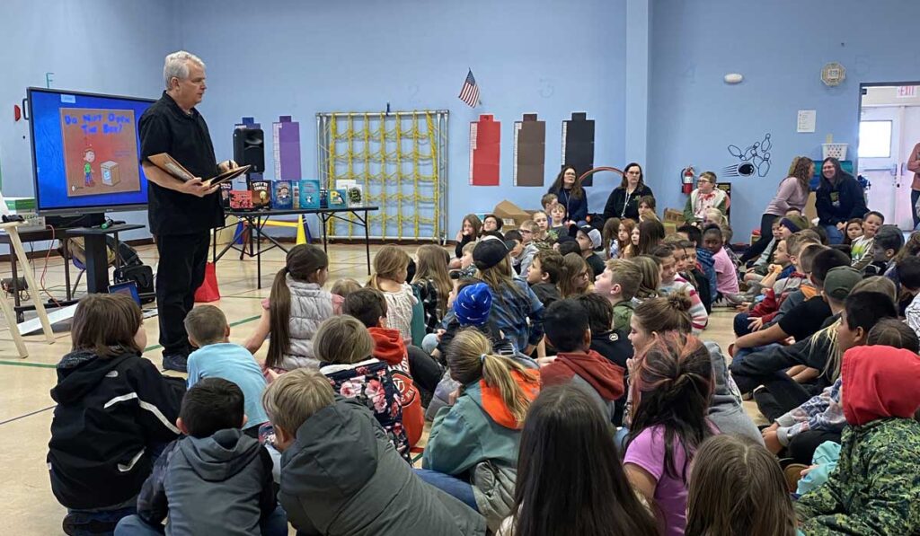 Timothy Young presents in a middle school gym in Elko, Nevada